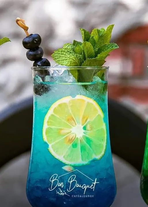 Three lemonades with mint and lime, a blue one in the middle