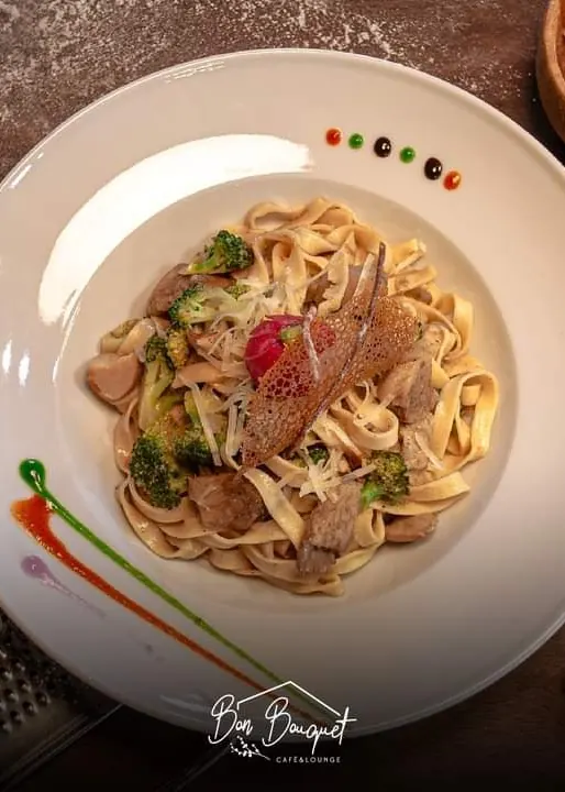 Fresh homemade tagliatelle with broccoli and parmesan in a wide white bowl